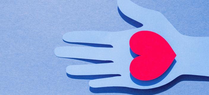 flat-lay-paper-hand-holding-heart-with-copy-space